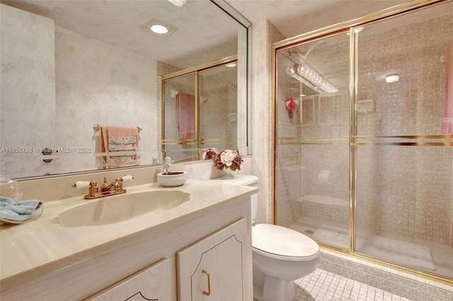 bathroom featuring vanity, toilet, a stall shower, and tile patterned flooring