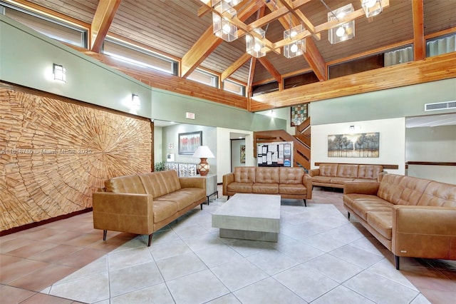 tiled living area with visible vents, wood ceiling, beam ceiling, an inviting chandelier, and a towering ceiling