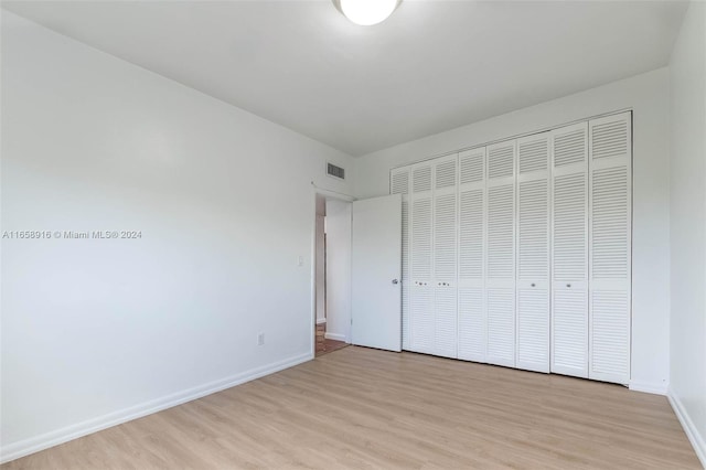 unfurnished bedroom with a closet and light hardwood / wood-style floors