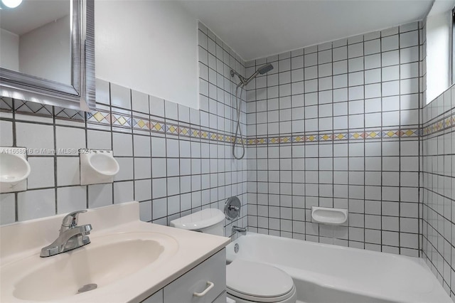 full bathroom with toilet, vanity, backsplash, tiled shower / bath combo, and tile walls