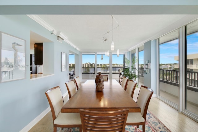 dining room with a textured ceiling, crown molding, a wall of windows, and hardwood / wood-style floors