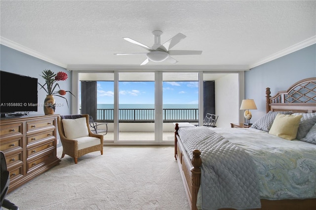 carpeted bedroom featuring a textured ceiling, ornamental molding, and ceiling fan