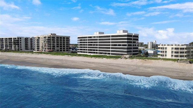 view of swimming pool featuring a view of the beach and a water view