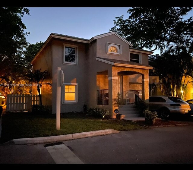 front facade with a porch and a yard