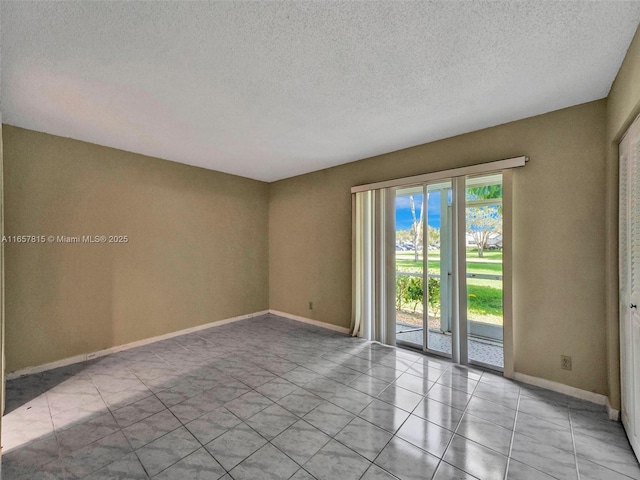 unfurnished room with light tile patterned flooring and a textured ceiling