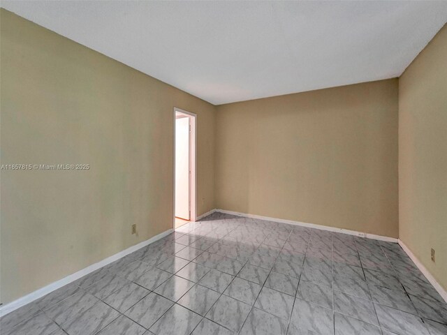 tiled spare room featuring a textured ceiling