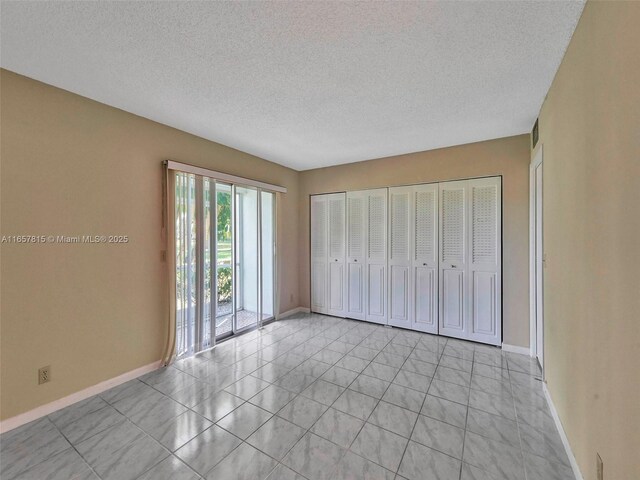 unfurnished bedroom with a textured ceiling and light tile patterned floors