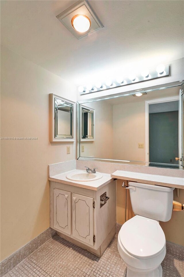 bathroom with tile patterned flooring, vanity, and toilet