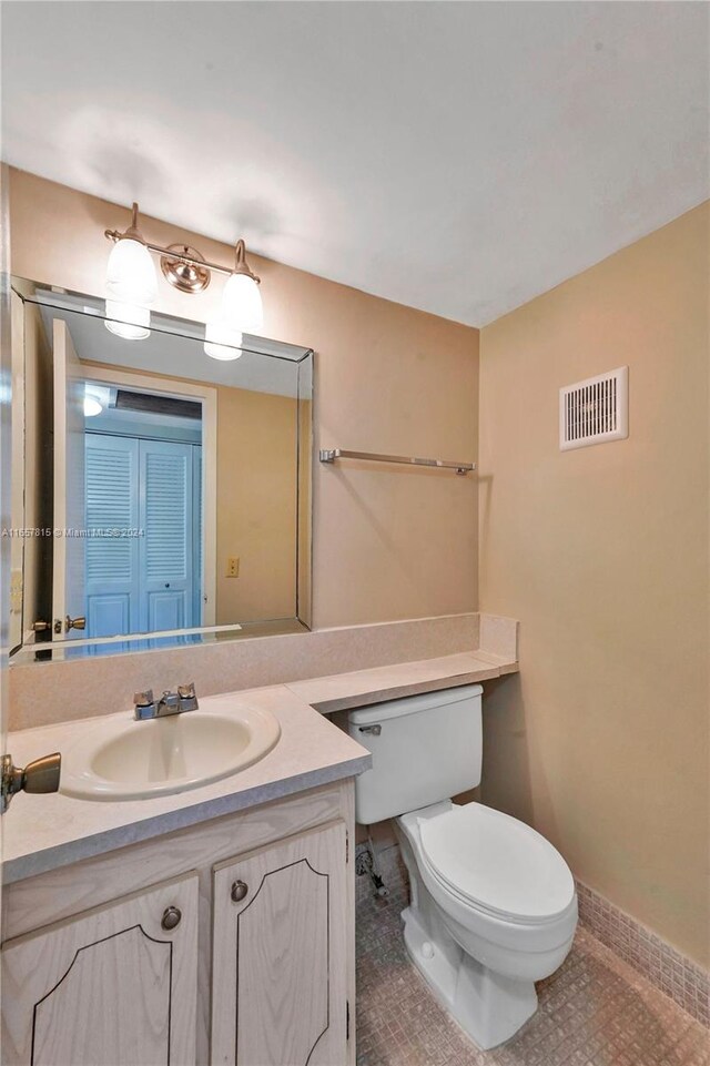 bathroom with tile patterned flooring, vanity, and toilet