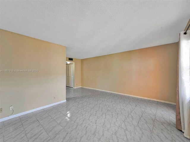 tiled spare room with a textured ceiling