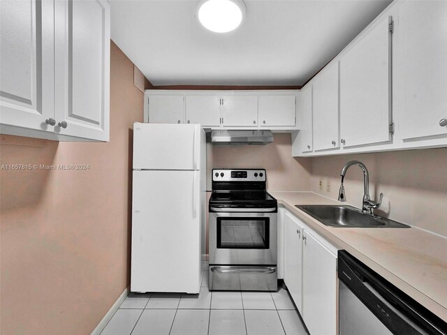 kitchen with stainless steel appliances, sink, light tile patterned floors, and white cabinets