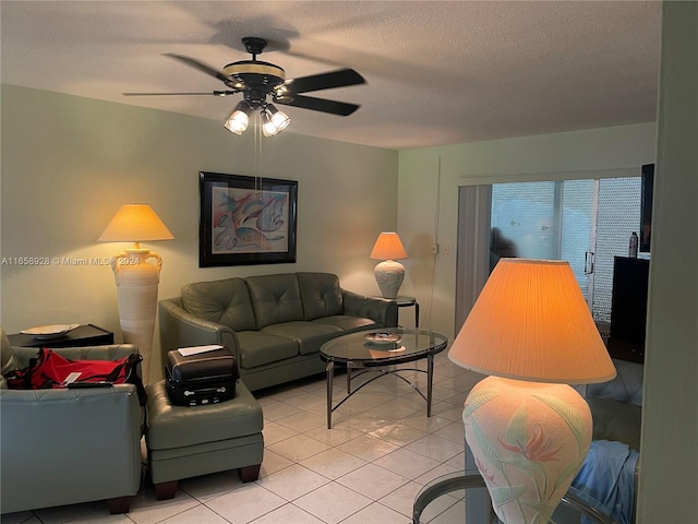 living room featuring ceiling fan, light tile patterned floors, and a textured ceiling