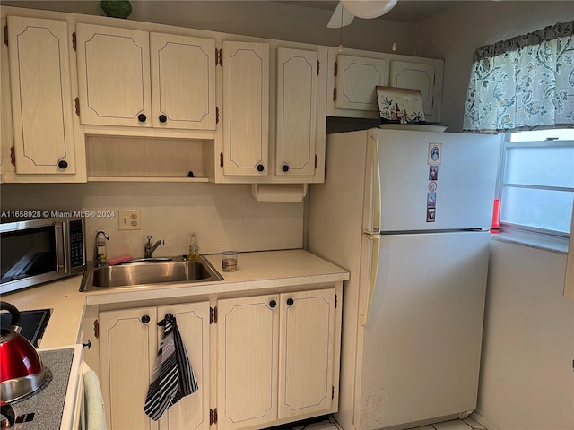 kitchen featuring ceiling fan, white fridge, sink, and white cabinets