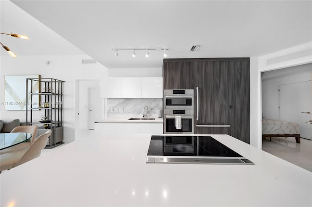 kitchen with white cabinets, sink, dark brown cabinets, black electric cooktop, and stainless steel double oven