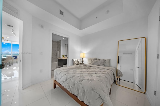 bedroom featuring ensuite bathroom and light tile patterned flooring