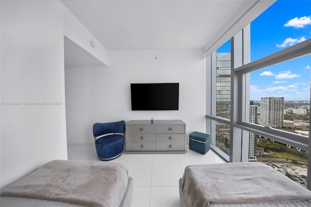 bedroom with multiple windows, a wall of windows, and light tile patterned flooring