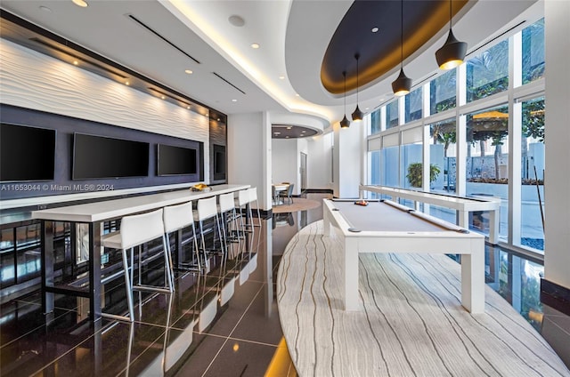 game room with a raised ceiling and billiards