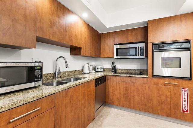 kitchen with light stone countertops, light tile patterned floors, stainless steel appliances, and sink