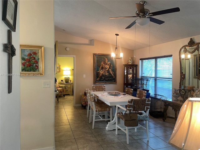 dining room with tile patterned flooring, ceiling fan with notable chandelier, a textured ceiling, and vaulted ceiling