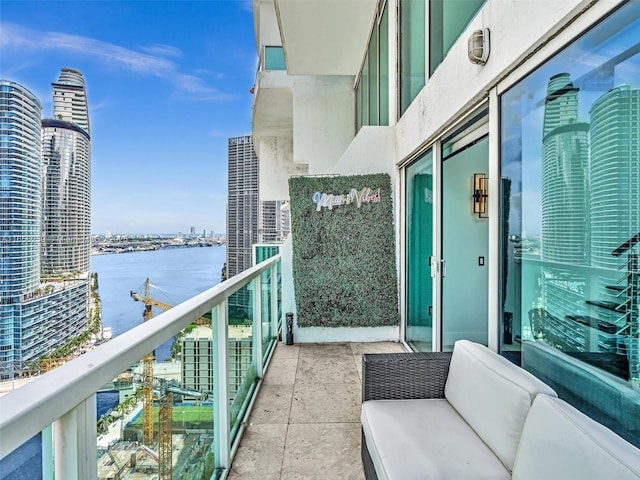 balcony featuring a water view and a city view