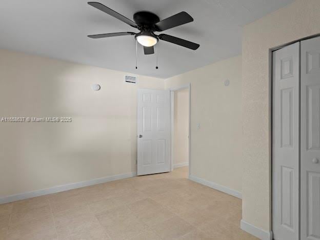 unfurnished bedroom featuring ceiling fan and a closet