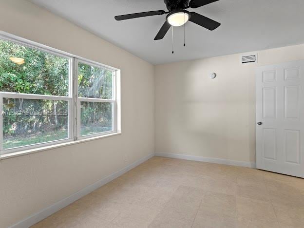 unfurnished room with a wealth of natural light and ceiling fan