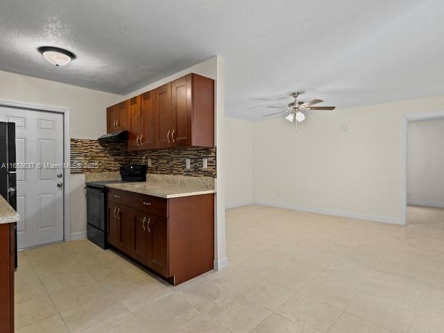 kitchen featuring black appliances, ceiling fan, and backsplash