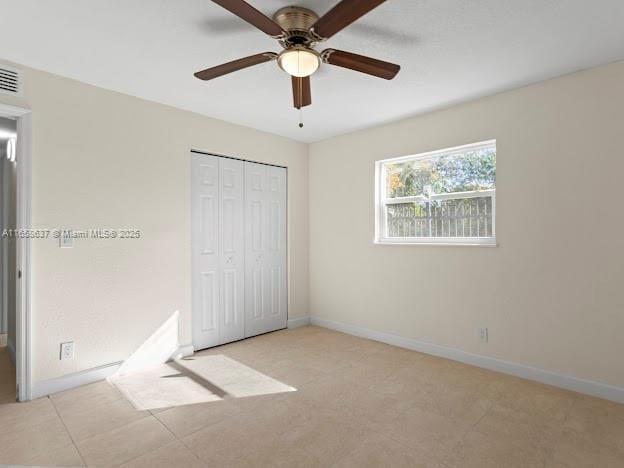 unfurnished bedroom featuring ceiling fan and a closet