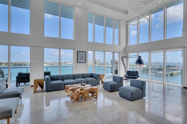 7939 E Dr Unit 15, North Bay Village, FL 33141 - living room featuring a water view, a chandelier, and a high ceiling