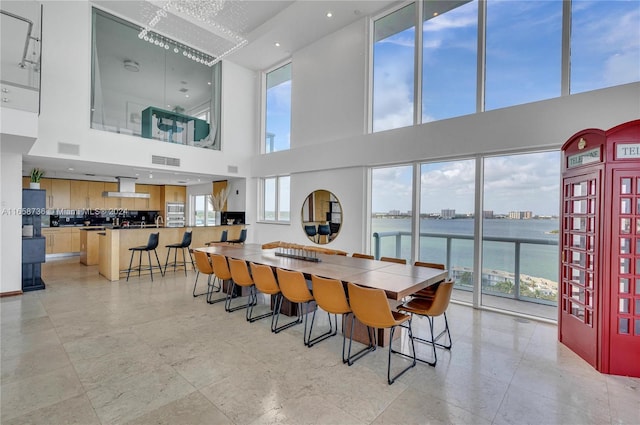 7939 E Dr Unit 15, North Bay Village, FL 33141 - dining space with a towering ceiling, a water view, and a wealth of natural light
