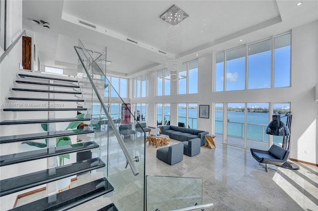 7939 E Dr Unit 15, North Bay Village, FL 33141 - interior space with a tray ceiling, ceiling fan with notable chandelier, a water view, and a high ceiling