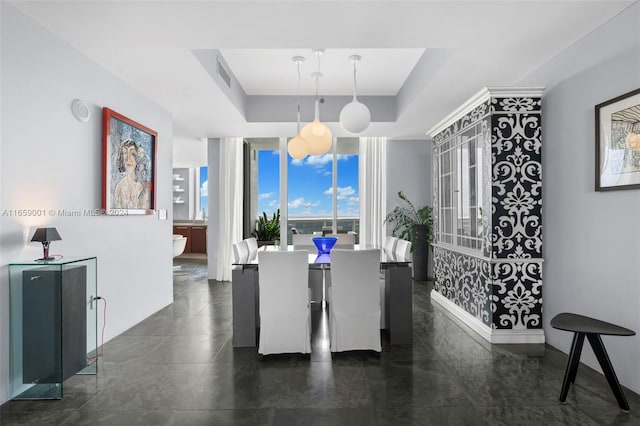 dining area with a raised ceiling