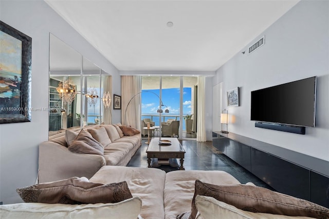 living room with a chandelier and a wall of windows