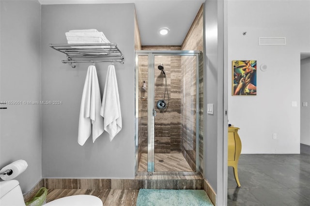 bathroom with a shower with shower door, toilet, and hardwood / wood-style flooring