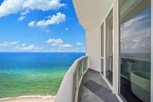 balcony featuring a water view and a view of the beach