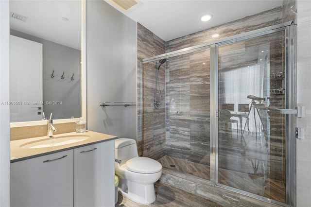 bathroom with vanity, toilet, and a shower with shower door