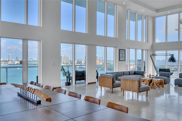 living room with a water view and a high ceiling