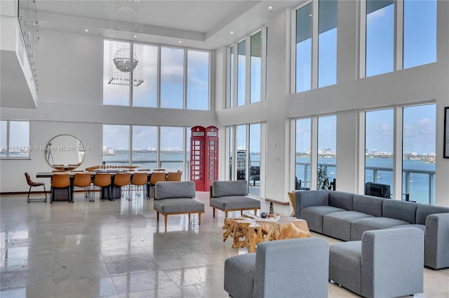 living room with a water view and a high ceiling