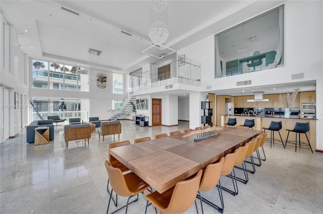 dining room with a towering ceiling and a chandelier