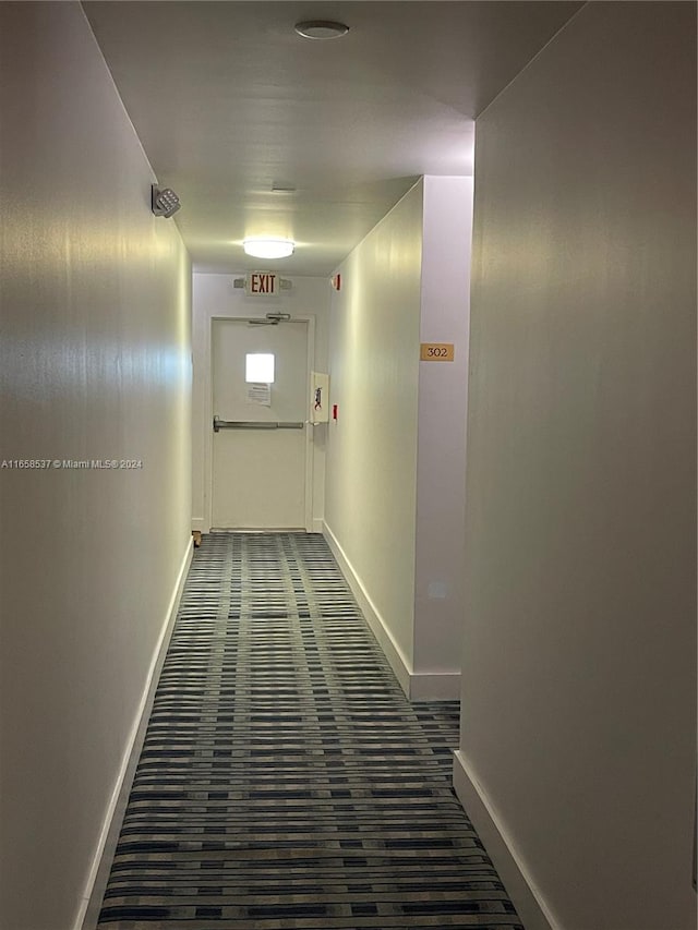 hallway featuring dark colored carpet