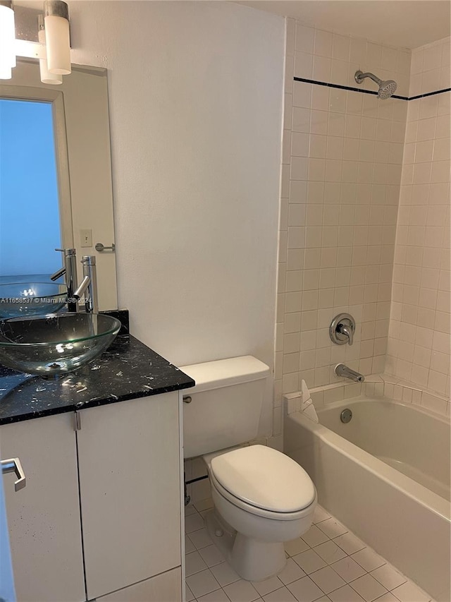 full bathroom with tiled shower / bath combo, vanity, toilet, and tile patterned flooring