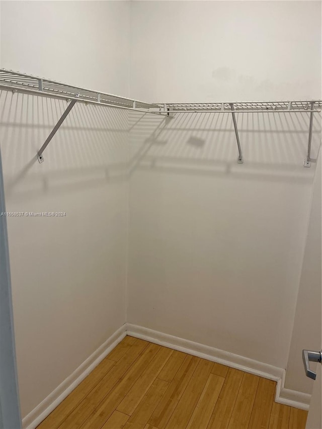 walk in closet with hardwood / wood-style floors