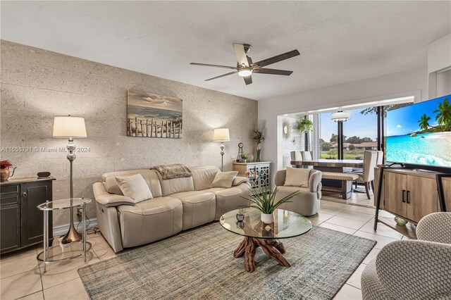 living room with tile walls, ceiling fan, and light tile patterned floors