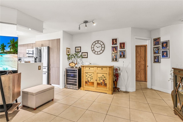 interior space featuring light tile patterned floors, stainless steel fridge with ice dispenser, and wine cooler