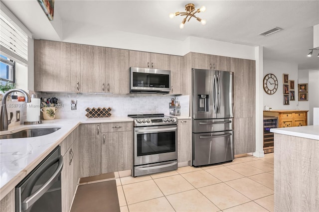 kitchen featuring wine cooler, light tile patterned flooring, sink, a notable chandelier, and stainless steel appliances