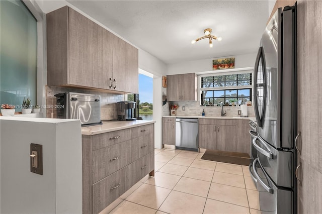 3507 Emerald Oaks Dr Unit 1804, Hollywood, FL 33021 - kitchen featuring light tile patterned flooring, light countertops, decorative backsplash, and appliances with stainless steel finishes