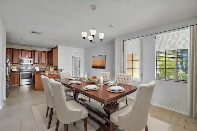 dining room featuring light tile patterned flooring and a notable chandelier