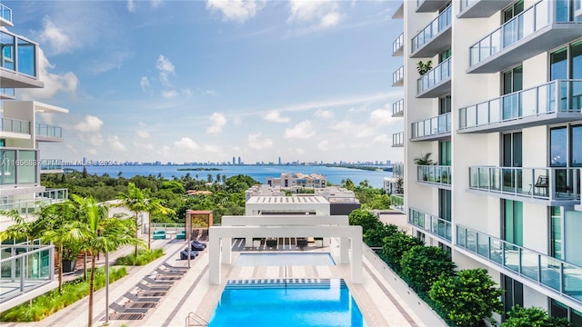 view of pool featuring a patio and a water view