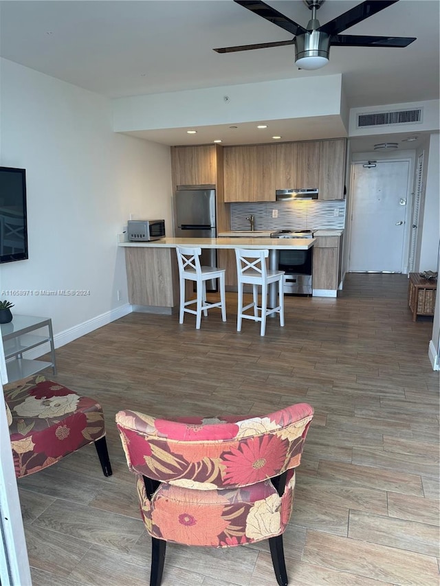 living room featuring ceiling fan and light hardwood / wood-style floors