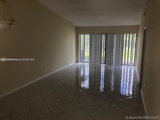 spare room with dark tile patterned flooring